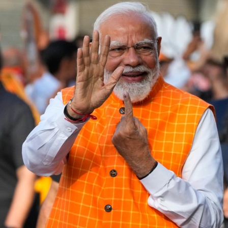 Indien, Ahmedabad: Der indische Premierminister Narendra Modi zeigt den unauslöschlichen Tintenfleck auf seinem Zeigefinger, nachdem er in der dritten Phase der Parlamentswahlen seine Stimme abgegeben hat. 