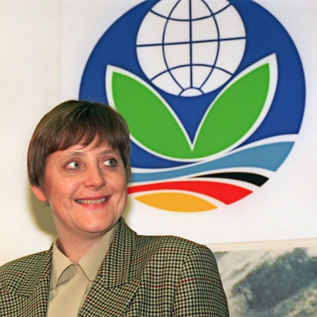 Bundesumweltministerin Angela Merkel vor dem Logo der UN-Klimakonferenz, die vom 28. März bis 7. April 1995 in Berlin stattfindet