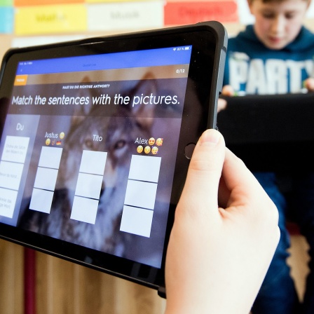 Schüler einer 5. Klasse lernen mit iPads im Englischunterricht