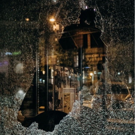 Eine zerbrochene Fensterscheibe gibt den Blick frei auf die Straße.