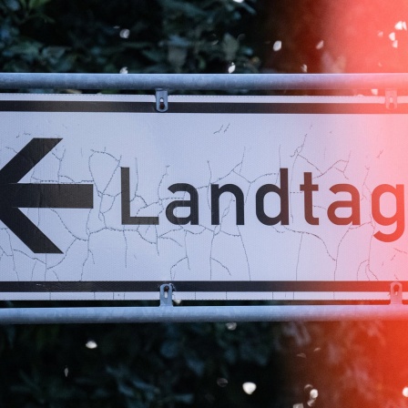 Blick auf ein ein Straßenschild mit dem Schriftzug "Landtag". 