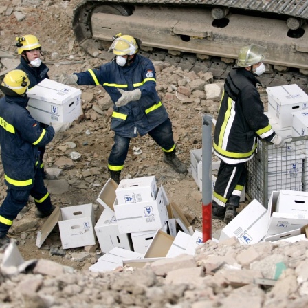 THW-Mitarbeiter packen Kartons - Bergung von Archivalien bei Aufräumarbeiten am eingestürzten Kölner Stadtarchiv