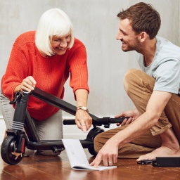 Enkel erklärt seiner Großmutter den E-Roller.