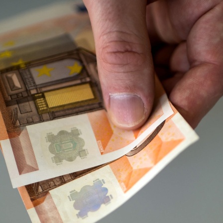 Hand hält Geldscheine