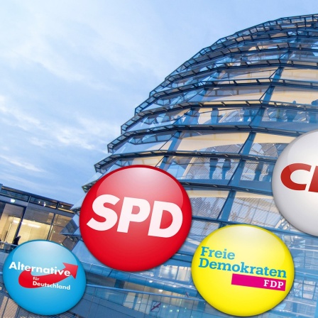 Die Glaskuppel des Bundestages mit Parteienlogos.