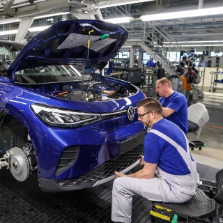 Mitarbeiter montieren den Stoßfänger an einem ID.4 im Werk von Volkswagen in Zwickau