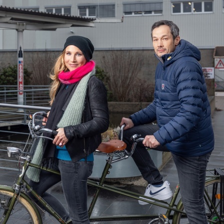 Fränzi Kühne und Boontham Temaismithi auf einem Tandem vor dem Firmengebäude von Edding.
