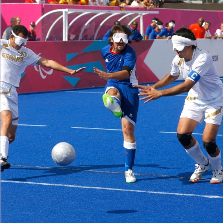 06 September 2012: Paralympics London 2012 - Blindenfussball, 3 Männer mit Augenbinden spielen Fußball
      