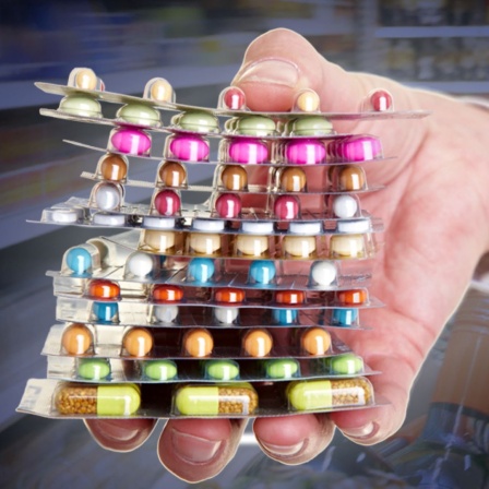 Hand mit Medikamenten (Montage)
