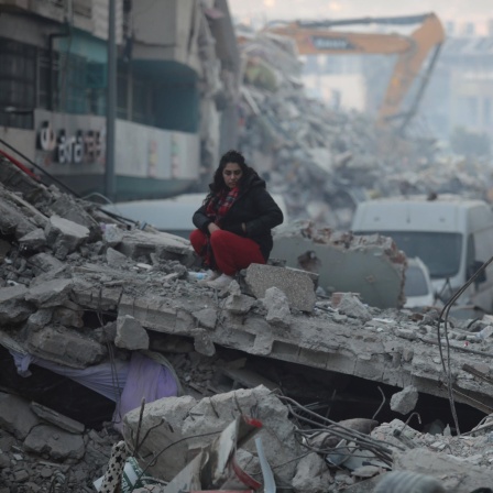Eine Frau sitzt auf den Trümmern eines vollkommen zerstörten Hauses in der türkischen Stadt Iskenderun. 