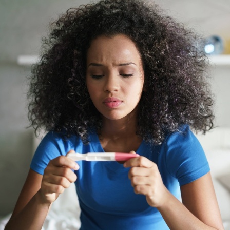 Eine Frau schaut auf einen Schwangerschaftstest