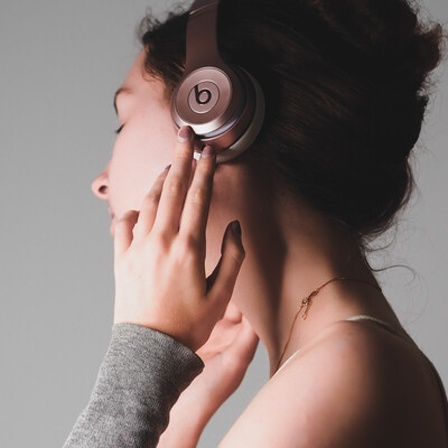 Eine Frau hat Kopfhörer auf und hört Musik.