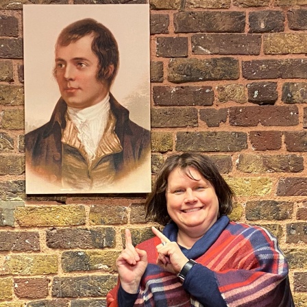 London Korrespondentin Gabi Biesinger zeigt auf ein Porträt vom schottischen Dichter Robert Burns 