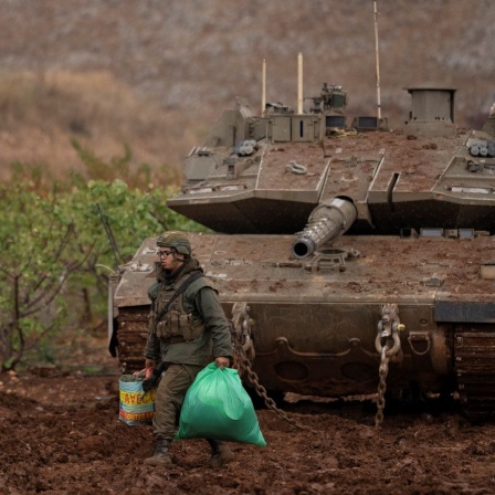 Ein israelischer Soldat geht an einem Panzer in der Nähe der israelisch-libanesischen Grenze vorbei, gesehen von Nordisrael aus.