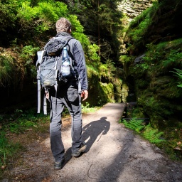 Ein Wanderer läuft in der Nähe von Rathen (Sachsen) von der Bastei kommend durch eine typische Schlucht (genannt "Schwedenlöcher") in der Nationalparkregion Sächsische Schweiz.