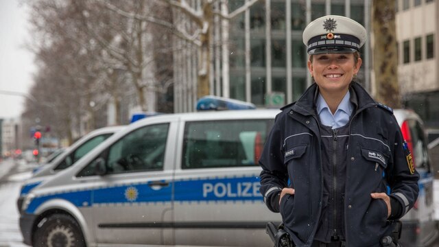 Die Polizeihauptmeisterin und Miss Germany 2019 Nadine Berneis steht in Uniform vor einem Polizeiwagen