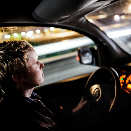 Eine junge Frau fährt in der Nacht mit ihrem Auto auf der Autobahn (Bild: picture alliance / photothek / Thomas Trutschel)