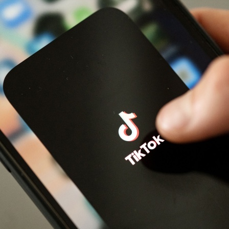 Ein Finger tippt auf einem Smatphone auf die App TikTok.