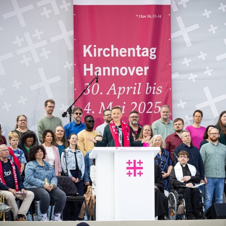 Menschen nehmen am Open-Air-Abschluss-Gottesdienst zum Kirchentag 2025 in Hannover teil.