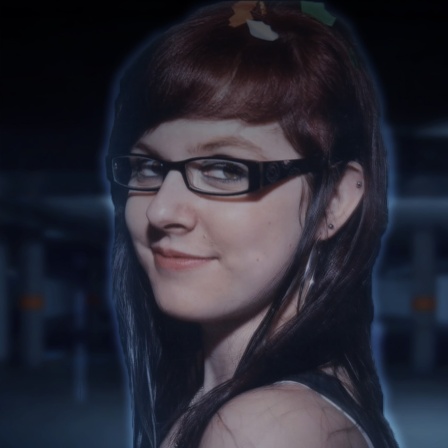 Eine junge Frau mit schwarzer, schmaler Brille lächelt in die Kamera.