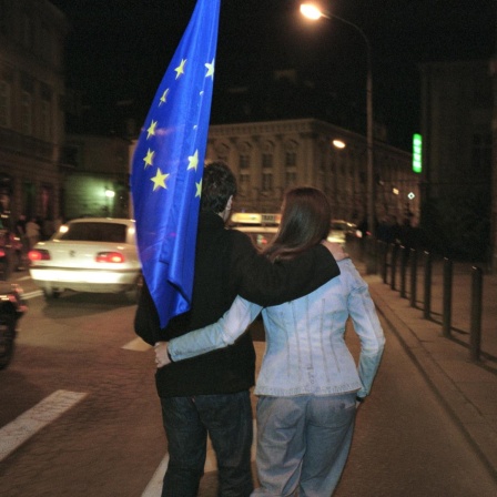 01.05.2004, Warschau, Masowien, Polen - Ein junges Paar unterwegs mit einer Europa-Flagge. 
