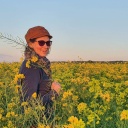 Die Autorin Freya Siewert mit Mütze in einem blühenden Rapsfeld