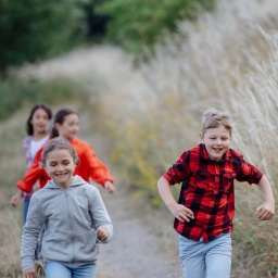 Kinder haben Spaß und rennen den Feldweg entlang.