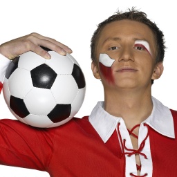 Ein junger Mann in rot-weißem Trikot und mit einem Fußball