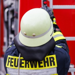 Ein Feuerwehrmann hantiert an einem Einsatzwagen.