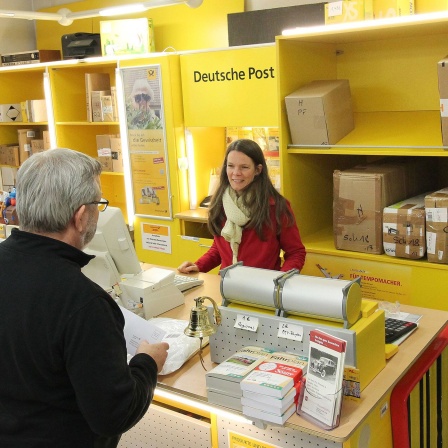 Kunde und Mitarbeiterin einer Deutschen Post Partnerfiliale
