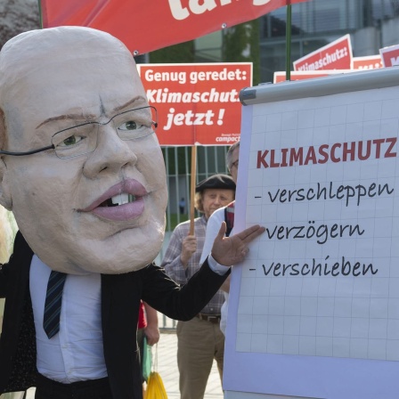 Demonstranten mit Transparenten und einer Maske von Bundeswirtschaftsminister Altmeier zum Thema Klimaschutz