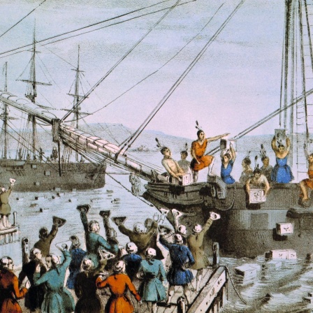 Als Native American verkleidete Kolonisten werfen im Hafen von Boston aus Protest gegen Importzoelle und Teemonopol die Ladung britischer Teeschiffe ins Wasser. (Lithgrafie)