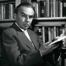 Erich Kästner 1959 vor einem Bücherregal