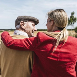 Zwei Personen, die Frau stützt den Mann, beide lachen