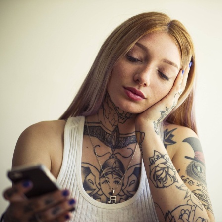 Junge Frau swiped auf ihrem Handy