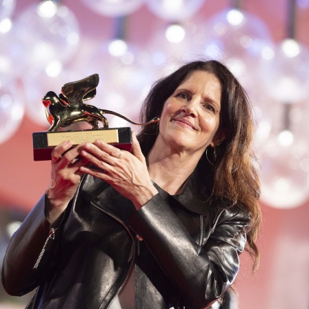 Laura Poitras mit ihrem Goldenen Löwen, der ihr 2022 beim Film Festival in Venedig für "All the Beauty and the Bloodshed" verliehen wurde. _foto: picture alliance/Stringer/Anadolu Agency