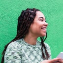 Eine lachende Frau mit einem Smartphone in den Händen