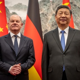 Bundeskanzler Olaf Scholz (SPD) und Chinas Staatspräsident von China, Xi Jinping, stehen vor deutschen und chinesischen Flaggen und blicken in die Kamera. 
