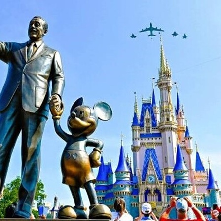 Eine Bronzestatue von Walt Disney und Mickey Mouse steht in Disney World Orlando vor dem Cinderellaschloss.