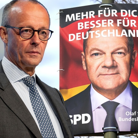 Friedrich Merz, CDU-Parteivorsitzender, vor einem Wahlplakat der SPD mit Bundeskanzler Olaf Scholz.