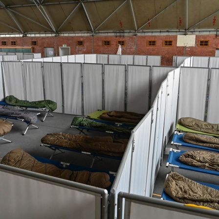 In einer Turnhalle stehen Feldbetten mit Schlafsäcken auf dem Gelände der Zentralen Erstaufnahmeeinrichtung für Asylbewerber (ZABH) des Landes Brandenburg. 