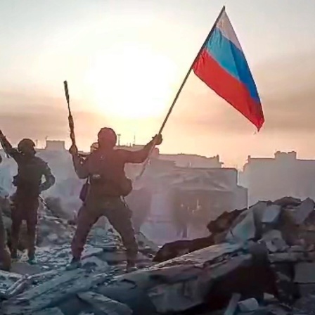 Soldaten schwenken eine Russlandfahne und eine Wagner-Flagge, Videostill aus einem Posting des Prigoschin Press Service