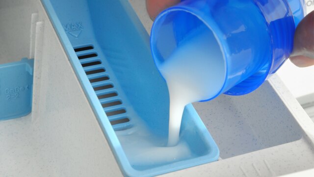 Flüssigwaschmittel wird in eine Waschmaschine gefüllt.