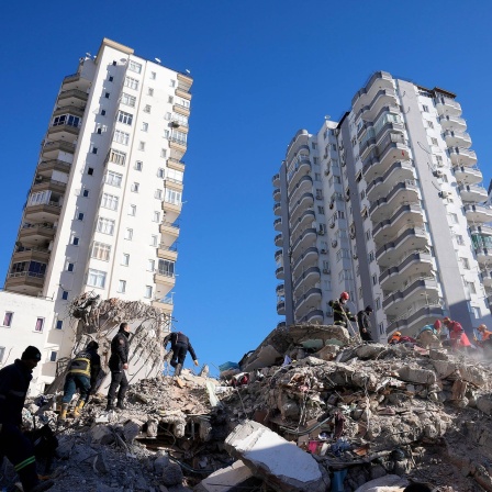 Notfallteams suchen nach Menschen in den Trümmern eines zerstörten Gebäudes