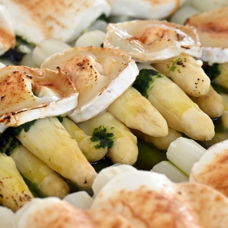 Überbackener Spargel liegt auf dem Buffet bei Feierlichkeiten zur Eröffnung der Spargelsaison auf einem Spargelhof.