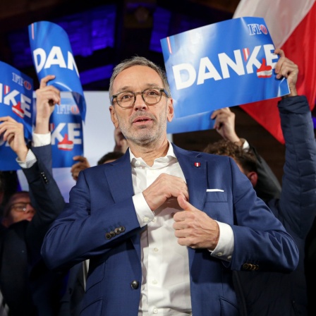 FPÖ-Chef Herbert Kickl steht vor FPÖ-Mitgliedern, die Plakate mit der Aufschrift "Danke" hochhalten