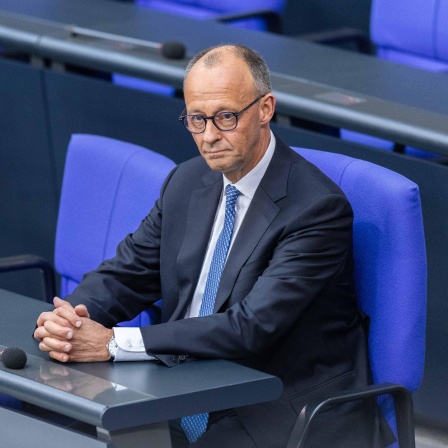 Friedrich Merz ( Bundeskanzler ) sitzt auf der Regierungsbank.