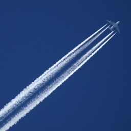 Ein Flugzeug der Qatar Airline hinterlässt am wolkenlosen Himmel Kondensstreifen.