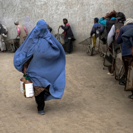 Eine afghanische Frau erhält in Kabul eine Lebensmittelration, die von einer humanitären Hilfsorganisation verteilt wurde.