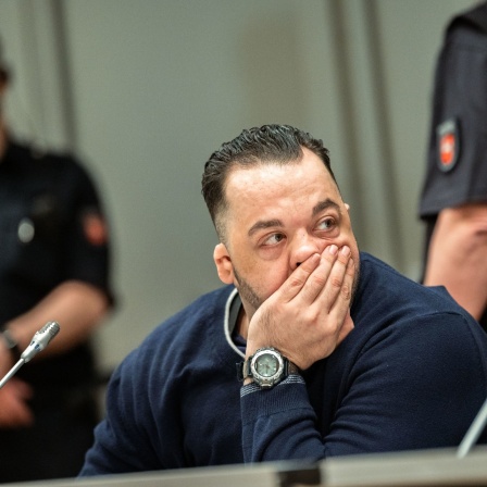 Der wegen Mordes an 100 Patienten an den Kliniken in Delmenhorst und Oldenburg angeklagte Niels Högel sitzt am Prozesstag mit seiner Hand am Gesicht im Gerichtssaal.